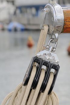 Close-up of a pulley with rope attached to boom of a sailboat