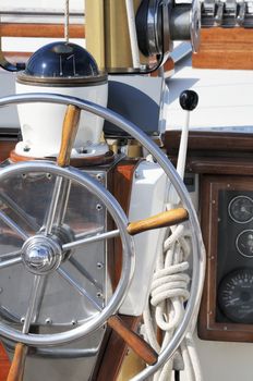 Detail of a wooden sailboat deck with rudder and compass