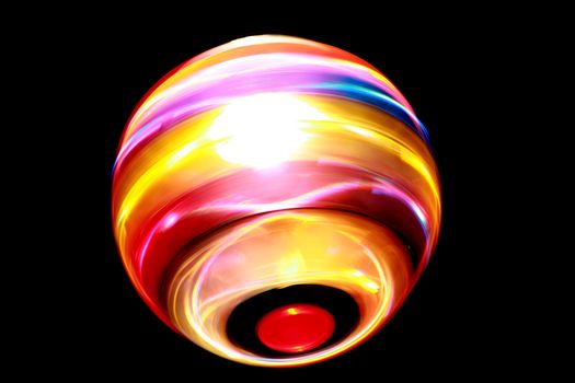 Blurred colorful ball of light spinning against dark background