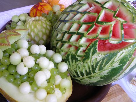 the beautifully carve fruits is on the festive table. 