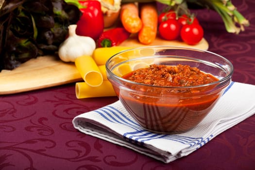 bowl with sauce bolognese and raw vegetables