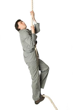 A man in a business suit climbing a rope