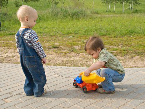 Two boys trying to repair a toy truck