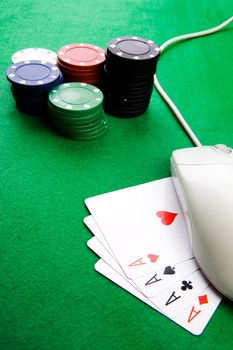 Online gaming and gambling concept, green felt, a mouse and cards