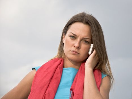 Young business woman in a red scarf speaks on a mobile phone. Portrait. Outdoor