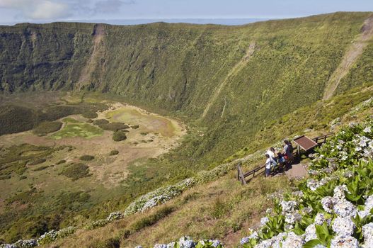 Tourists admiring Caldeira extinct volcano in Faial island, Azores, Portugal