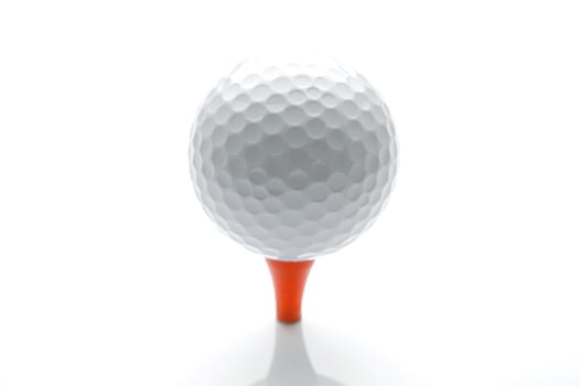 A golf ball on a tee isolated against a white background