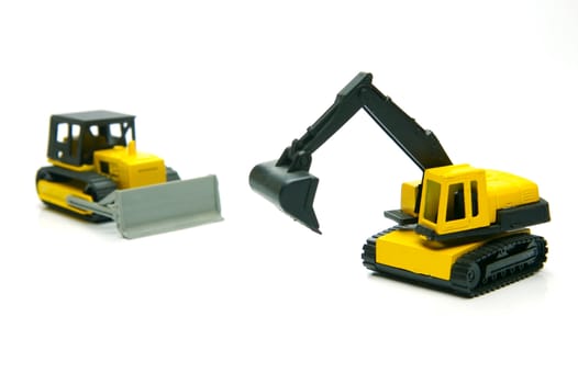 Miniature model earth moving equipment isolated against a white background