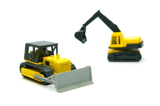 Miniature model earth moving equipment isolated against a white background