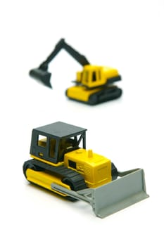 Miniature model earth moving equipment isolated against a white background