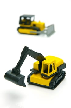 Miniature model earth moving equipment isolated against a white background