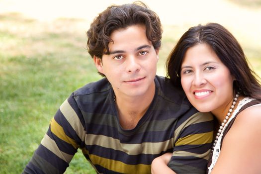 Attractive Hispanic Couple Portrait Enjoying Each Other Outdoors.