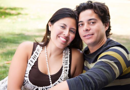 Attractive Hispanic Couple Portrait Enjoying Each Other Outdoors.