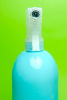 A spray bottle isolated against a blue background