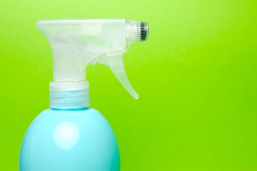 A spray bottle isolated against a blue background