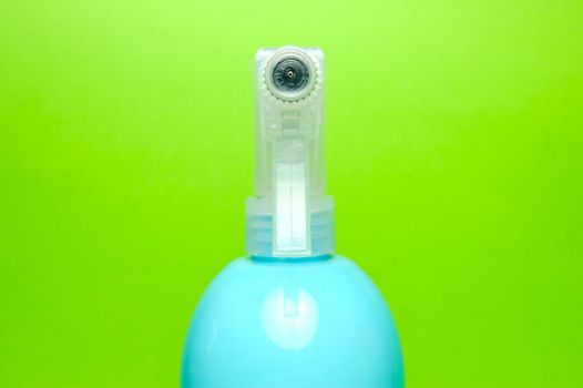 A spray bottle isolated against a blue background