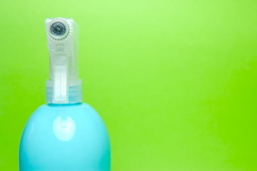 A spray bottle isolated against a blue background