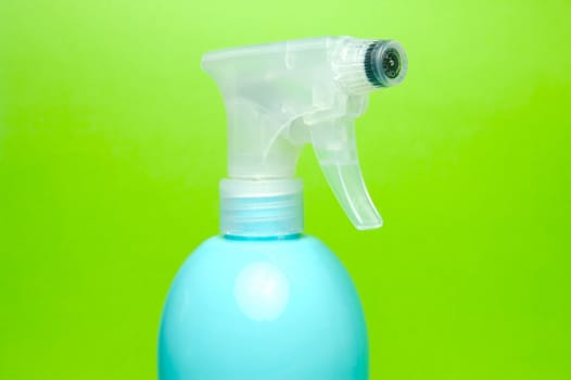 A spray bottle isolated against a blue background