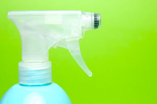 A spray bottle isolated against a blue background