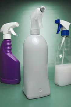 Cleaning products isolated against a green background