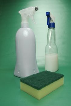 Cleaning products isolated against a green background