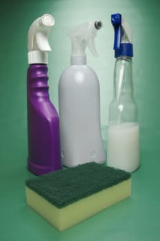 Cleaning products isolated against a green background