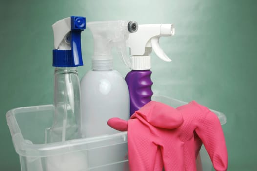 Cleaning products isolated against a green background