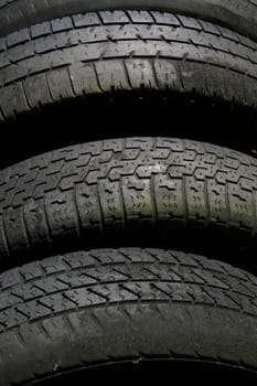 Old tyres showing tread lined up for recycling.