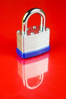 A padlock isolated against a red background