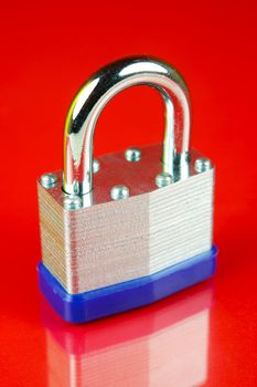 A padlock isolated against a red background