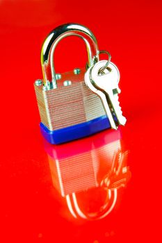 A padlock isolated against a red background