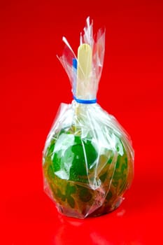 Green toffee apples isolated against a red background