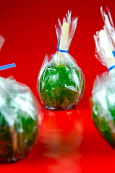 Green toffee apples isolated against a red background