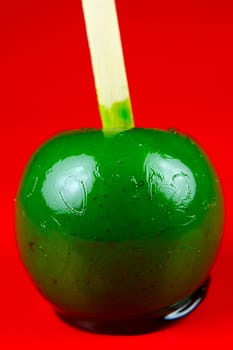 Green toffee apples isolated against a red background