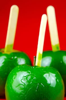 Green toffee apples isolated against a red background