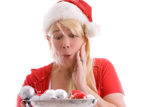 Woman with long blond hair and christmas hat looking surprised at the baubles