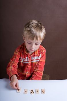 The little boy displays on a table of a card with figures