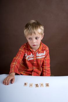 The little boy displays on a table of a card with figures