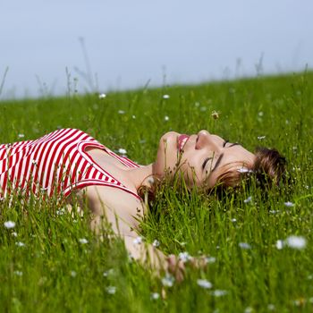 Young woman relaxing on a beautiful green meadow