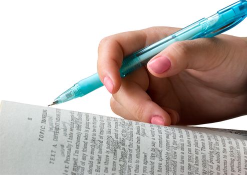 The female hand with a pencil lays on the opened book