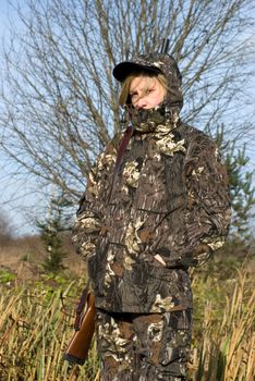 The girl dressed in a camouflage with a gun