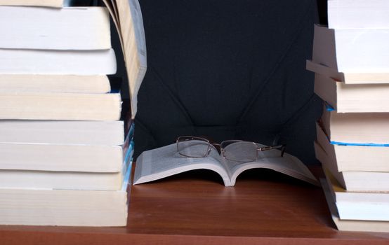 The opened book between two piles of books