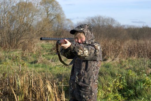 The girl in a camouflage aiming from a gun