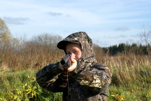 The girl in a camouflage aiming from a gun