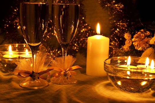 two glasses of champagne lightening with candle with decoration