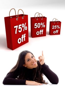 laying young woman pointing at the 
three dimensional shopping bags