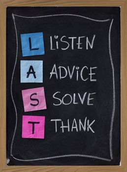 LAST (listen, advice, solve, thank) - acronym for training customer service and complaints handling. blackboard with sticky notes and white chalk handwriting