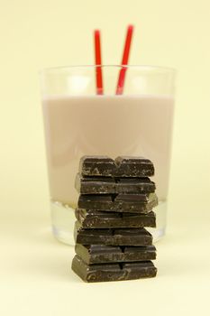 A glass of chocolate milk isolated against a yellow background