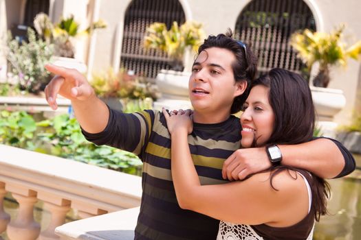 Attractive Hispanic Couple Portrait Enjoying Each Other Outdoors.