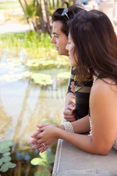 Attractive Hispanic Couple Overlook Pond Together Outdoors.